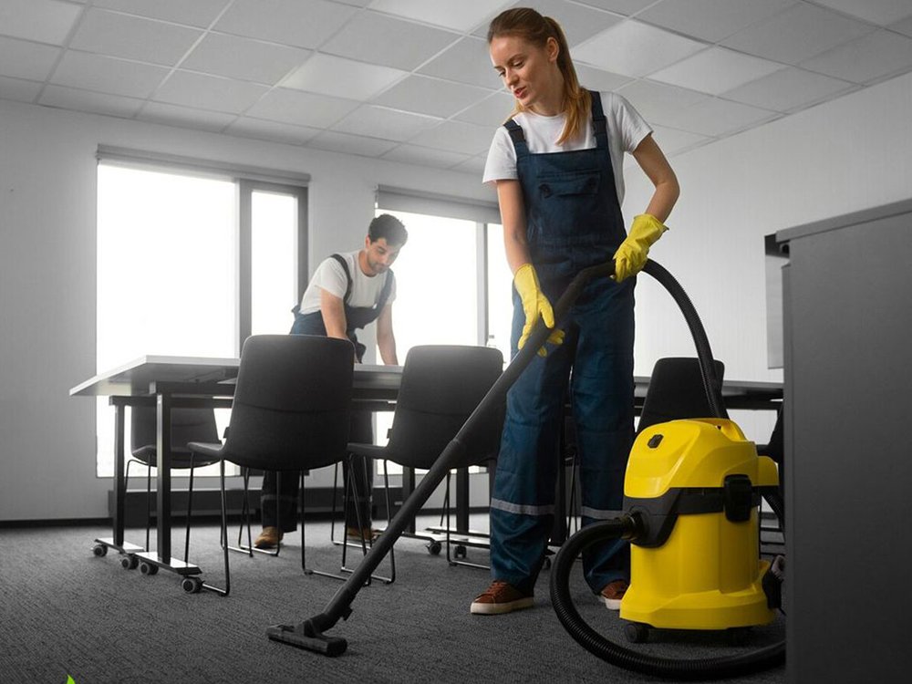 Technician vacuuming an office floor